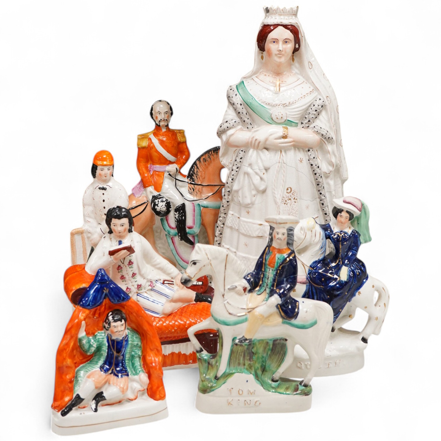 A collection of seven Staffordshire figures, including Queen Victoria - 45cm high, a cricketer, a boy reading, Tom King etc